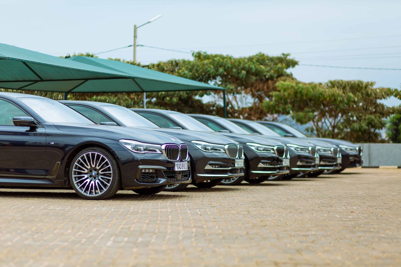 Row of luxury cars parked at an outdoor dealership, showcasing elegance.